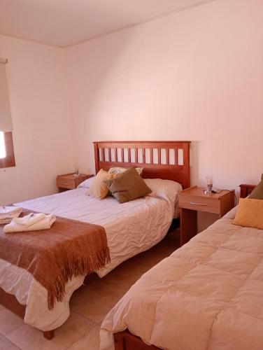 a bedroom with two beds and two night stands at La Carmela, Tilcara in Tilcara