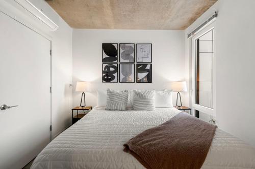 a white bedroom with a large bed with two lamps at Family-Sized 4BR Luxury in Downtown Chicago in Chicago