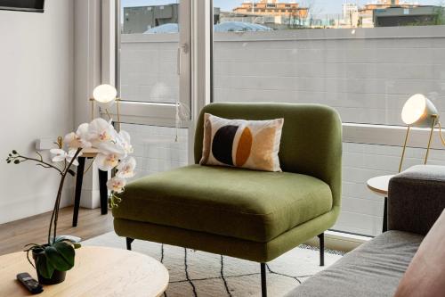 a green chair in a living room with a window at Family-Sized 4BR Luxury in Downtown Chicago in Chicago