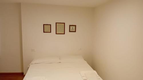 a bedroom with a bed with three pictures on the wall at Meraviglioso monolocale nuovissimo, appena ristrutturato in Carrara