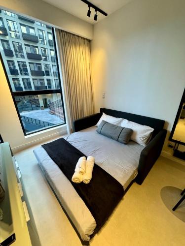 a large bed in a room with a large window at Studio b2b in Florianópolis