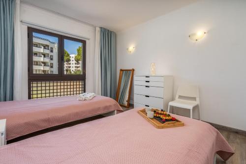 a bedroom with two beds and a window at Vilamoura Retreat with Pool & Balcony by HostWise in Quarteira