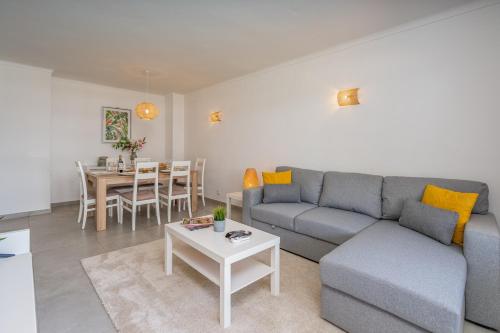 a living room with a couch and a table at Vilamoura Retreat with Pool & Balcony by HostWise in Quarteira