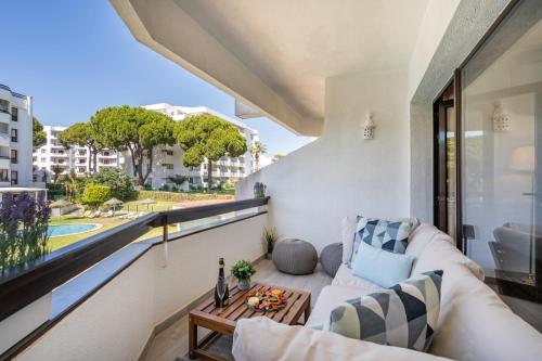 a balcony with a couch and a table at Vilamoura Retreat with Pool & Balcony by HostWise in Quarteira