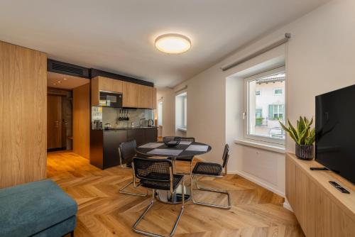 a living room with a table and chairs and a kitchen at Bertamini Apartments in Nago-Torbole