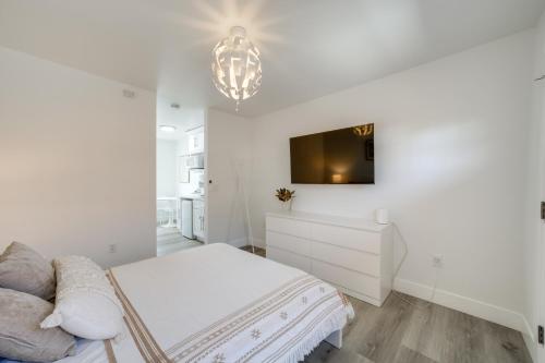 a white bedroom with a bed and a tv on the wall at Steps to Soap Lake Studio Stay with Patio! in Soap Lake