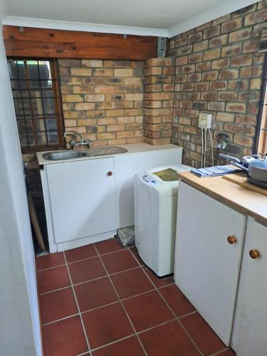 a kitchen with a sink and a washing machine at The Berg Surf Shack in Muizenberg