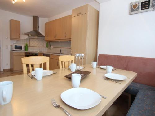 a dining room table with white plates and utensils at Mansion in Goldegg near Ski Lift in Goldegg