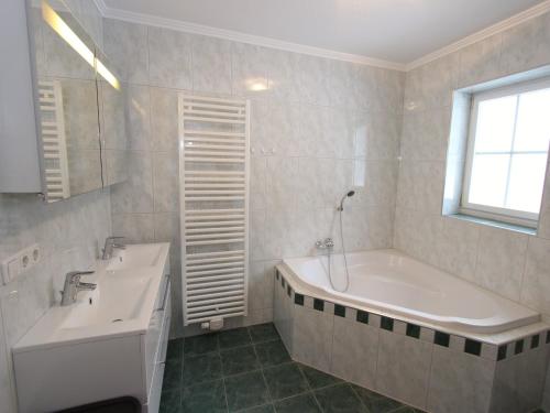 a white bathroom with a tub and a sink at Mansion in Goldegg near Ski Lift in Goldegg