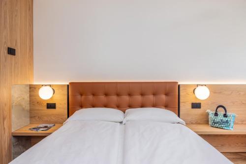 a bedroom with a large bed with two lights at Bertamini Apartments in Nago-Torbole
