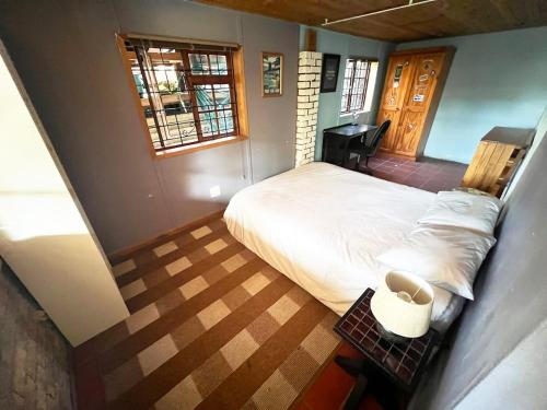 een slaapkamer met een groot bed en een raam bij The Berg Surf Shack in Muizenberg