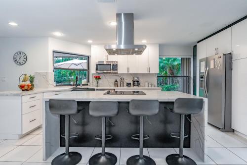 una cocina con una isla grande con 4 taburetes en Fox Island Heated Spa- Downtown & Beach, en Fort Lauderdale