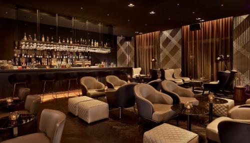 a bar with a bunch of chairs and a counter at Park Plaza Victoria Amsterdam in Amsterdam