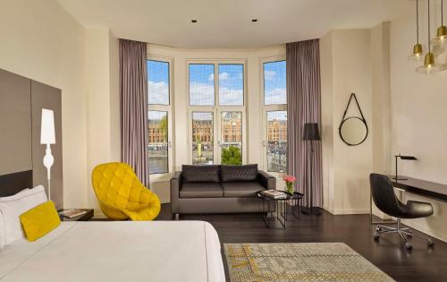 a hotel room with a bed and a couch and windows at Park Plaza Victoria Amsterdam in Amsterdam