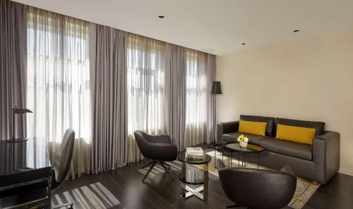 a living room with a couch and a table and chairs at Park Plaza Victoria Amsterdam in Amsterdam
