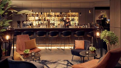 a bar with a man standing behind a counter at Park Plaza Victoria Amsterdam in Amsterdam