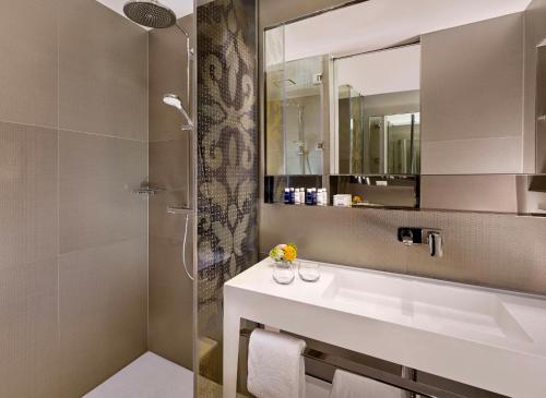 a bathroom with a sink and a shower at Park Plaza Victoria Amsterdam in Amsterdam