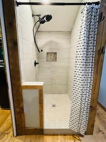 a shower in a bathroom with a shower curtain at Jai Hollow Tiny Home Cottage in Robbinsville