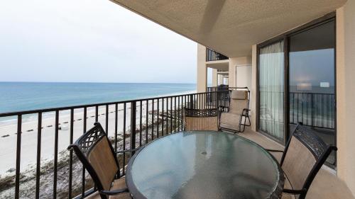 un balcon avec une table et des chaises et la plage dans l'établissement Phoenix V 715, à Orange Beach