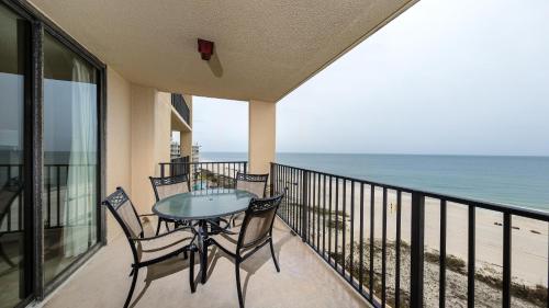 un balcon avec une table et des chaises et l'océan dans l'établissement Phoenix V 715, à Orange Beach