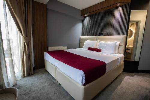 a bedroom with a large bed with a red blanket at View Inn Boutique Hotel in Skopje