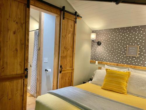 a bedroom with a bed with a wooden headboard at Jai Hollow Tiny Home Cottage in Robbinsville