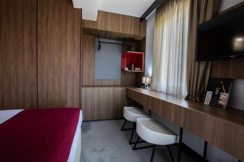 a hotel room with a bed and a row of chairs at View Inn Boutique Hotel in Skopje