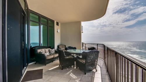 a balcony with a table and chairs and the ocean at Phoenix West 1103 in Orange Beach