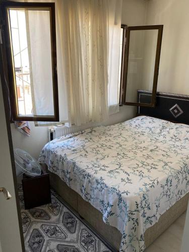 a bedroom with a bed and two windows at Star Apartment Derya Izmir in Konak