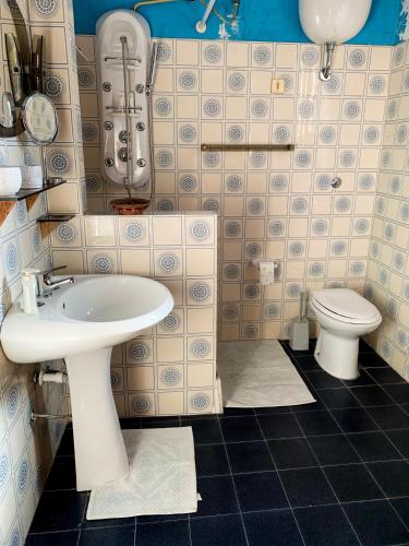 a bathroom with a sink and a toilet at Casa Vacanze Sos Vrades in Portoscuso