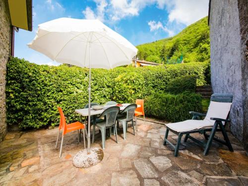 a patio with a table and chairs with an umbrella at Holiday Home in Pascoso near Forest in Pescaglia