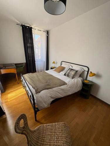 Un dormitorio con una cama y una silla dentro. en Il Piano Nobile, en Colmar