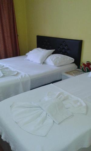 duas camas num quarto de hotel com lençóis brancos em Bereket traveler Hotel em Istambul