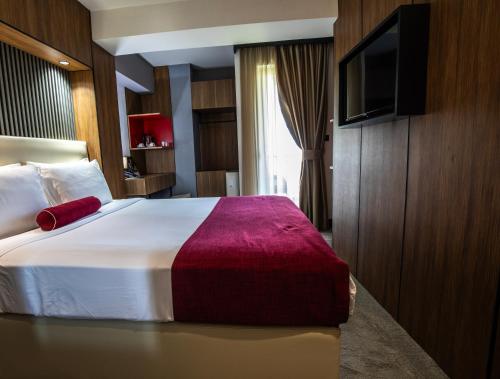 a bedroom with a large bed with a tv on a wall at View Inn Boutique Hotel in Skopje