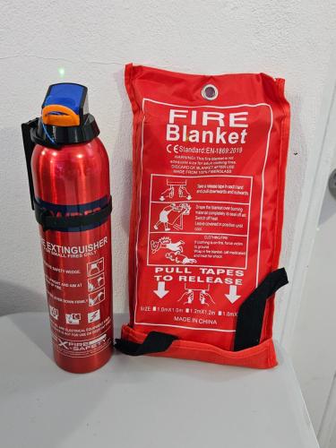 a red fire extinguisher next to a fire bag at Sunrise Haven Holiday Apartments Barbados in Christ Church