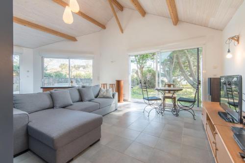 a living room with a couch and a table at La Préfaillaise - 800m plage - Parking in Préfailles