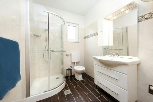 a bathroom with a sink and a shower and a toilet at Apartment Lili in Biograd na Moru