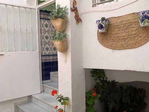 a house with plants in baskets on the wall at Casa Ana in Vejer de la Frontera