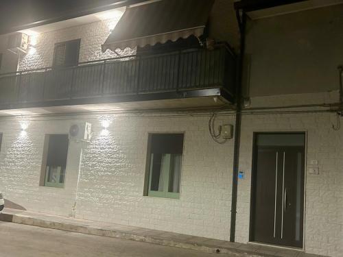 a white brick building with a balcony on top of it at Sicilia nel Cuore Apartment in Cassibile