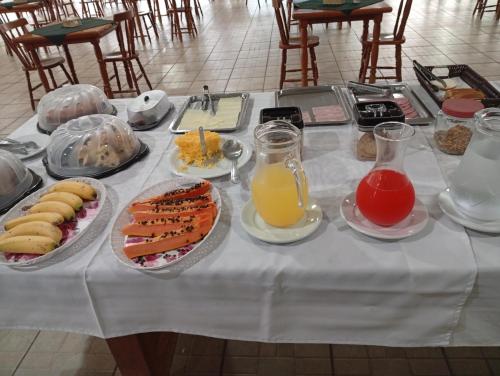 a table topped with plates of food and drinks at Hotel Castro Alves Norte in Marília