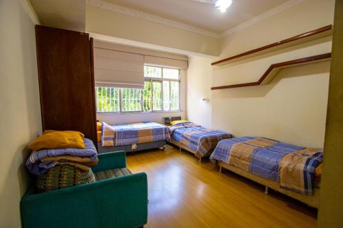 a room with three beds and a couch and a window at APT Perto da praia de Copacabana in Rio de Janeiro