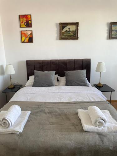 a bedroom with a large bed with two towels on it at 12 Home in Reghin