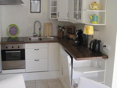 a kitchen with white cabinets and a wooden counter top at Luxurious holiday home with private pool in Buzon