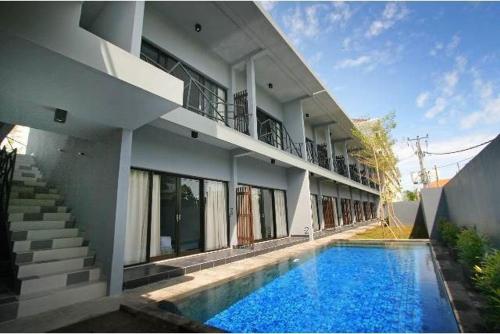 a building with a swimming pool in front of a house at The Grey Boutique Inn in Legian