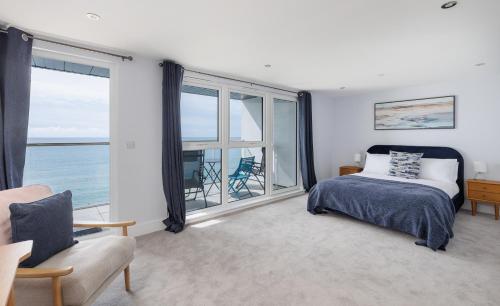 サンダウンにあるCulver Sands - Duplex Apartment with Stunning Sea Views on the Isle of Wightのベッドと大きな窓のある寝室