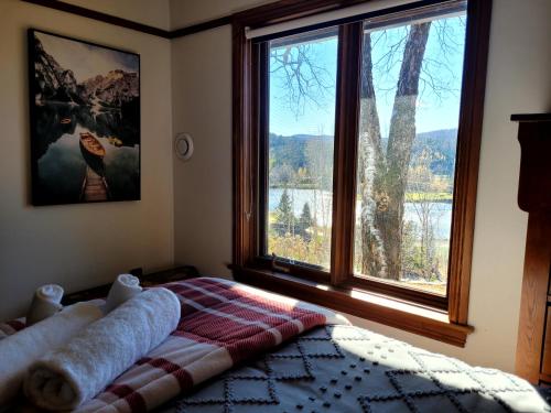 a bedroom with a bed and a large window at Lake views, spa, king bed, Golf Club amenities in Mont-Blanc