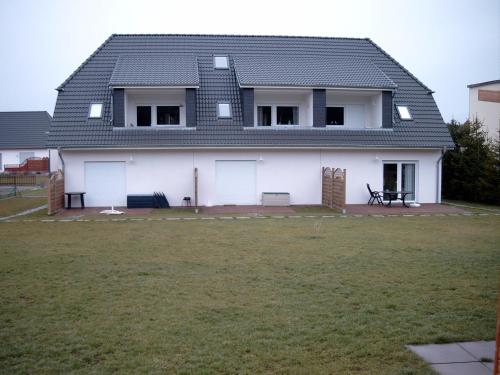 ein weißes Haus mit einem großen Hof davor in der Unterkunft Ferienwohnung Usedom Ostseebad Zempin in Zempin