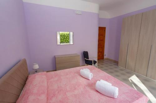 a bedroom with a bed with two white towels on it at Villa Azzurra Apartment Camilleri's Roads in Porto Empedocle