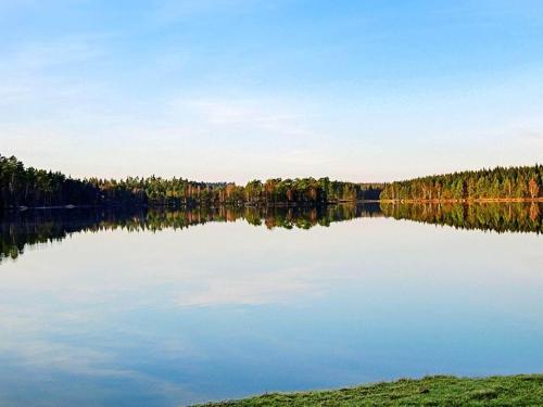 a large lake with trees in the background at 6 person holiday home in Vittsjö in Vittsjö