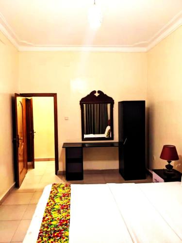 a room with a bed and a mirror and a table at Bati Valley Guest House in Kigali